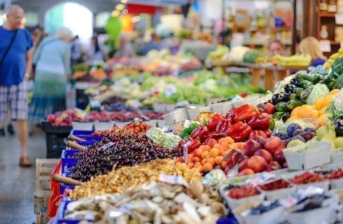 Market showing stands full of colorful fruits and vegetables
