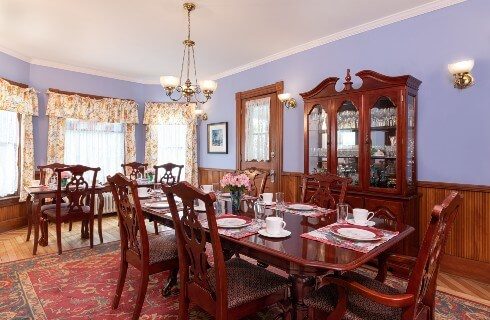 Elegant dining room with one table set for six and another set for four and antique china hutch